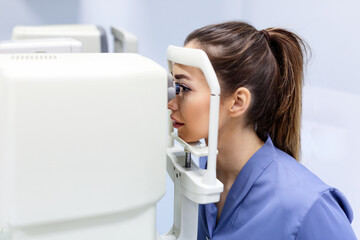 Doctor testing for eyes with special optical apparatus in modern clinic. Ophthalmologist examining...