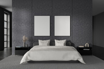 Dark bedroom interior with bed, two empty white posters