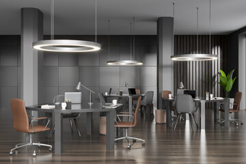 Workspace interior with armchair, table and laptop in coworking loft