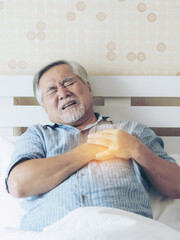 Senior male asian suffering from bad pain in his chest heart attack at home - senior heart disease