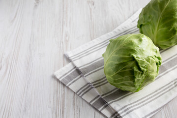 Raw Organic Cabbage on a white wooden background, side view. Copy space.