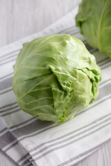 Raw Organic Cabbage on a white wooden background, side view. Close-up.