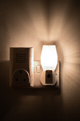 Close up of a night light plugged into a wall in a house
