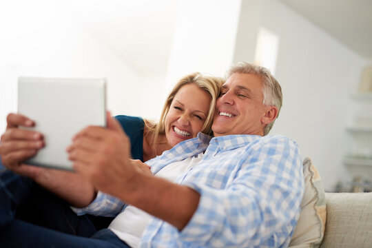 Lets show the world what love looks like. Cropped shot of a mature couple taking a selfie on a digital tablet at home.