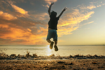 Child playing on ocean beach. Kid jumping in the waves at sunset. Sea vacation for family with kids. Little boy running on tropical beach of exotic island during summer holiday. © suvita style 