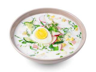 Okroshka with vegetables, fresh herbs and kefir is isolated on a white background.