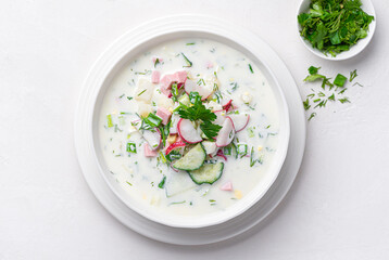 Summer, cold soup with cucumber, radish, egg, potatoes and fresh herbs seasoned with kefir.