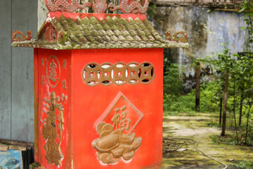 An old red spirit house with vintage carvings in the heritage town of Ipoh.