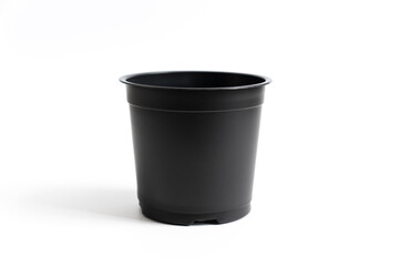 small black plastic pot for indoor flowers on a white background. accessories for seedlings of...
