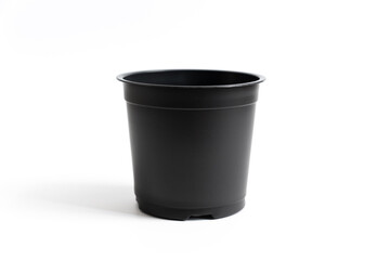 small black plastic pot for indoor flowers on a white background. accessories for seedlings of plants at home.