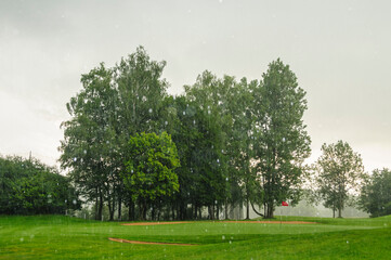 Unwetter mit heftigem Regen über dem Golfplatz
