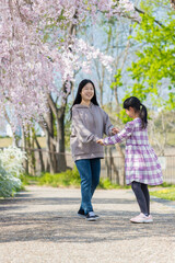 Obraz premium 春の公園で遊んでいる子供姉妹の姿