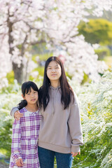 Fototapeta premium 春の公園で遊んでいる子供姉妹の姿