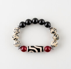 Bracelet made of amethyst and quartz,. A bracelet made of natural stones on the hand. Handmade jewelry on a white background.