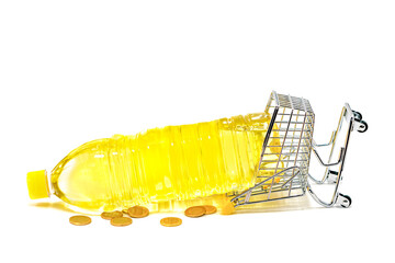 Shopping cart that has fallen because of the weight of a bottle of sunflower oil on white background. Concept of sunflower oil price increase. Selective focus.