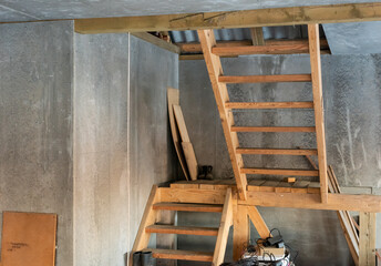 Fototapeta na wymiar repair and renovation in a wooden house temporary wooden staircase to the second floor