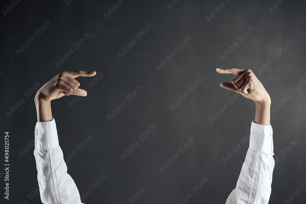 Poster check this out. shot of hands pointing to each other against a dark background.