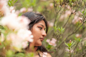 Portrait a young latina woman distracted among flowering trees