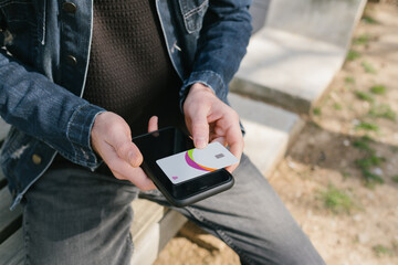 Credit card, young man's credit card is standing on his phone, online shopping preparation and bill payment, paid subscriptions and content payments