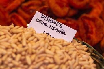 Bulk peeled pine nuts ready for sale, selective approach to the white sign, the sign translated...