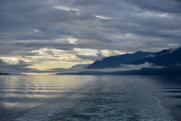 Clouds over mountains and ocean viewed from cruise ship as it sails from Canada to Alaska.