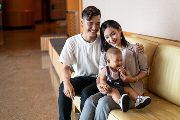 Malay Asian Young Couple with One Year Old Child Daughter, with light brown sofa chair