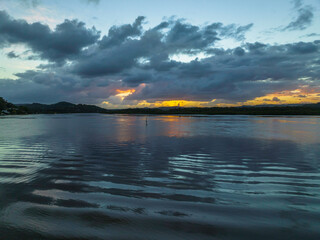 Sunrise waterscape and rain clouds reflections