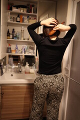 風呂上がりに髪をとかす女性