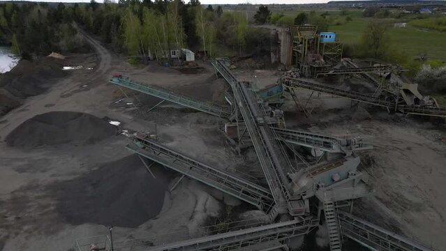 Aerial view basalt quarry of open pit mine machines with sifters and conveyor belts, Industry of black basalt stone, stone quarry