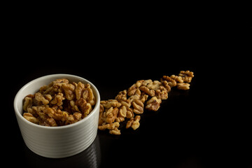 walnuts in a small bowl isolated on black