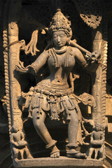 Fototapeta na wymiar Stone Sculpture of Beautiful Female (Madanikas) with selective focus, 12th century Hindu temple, Ancient stone art and sculptures in each pillars, Chennakeshava Temple, Belur, Karnataka, India.