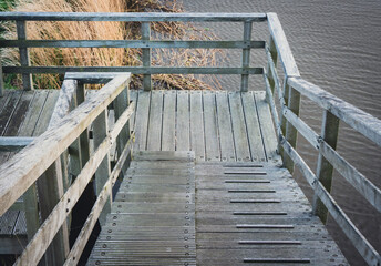 Drewniane schody, drewniane zejście z kładką nad kanałem.