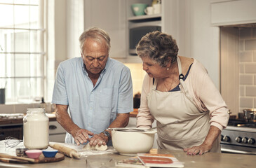 Youre doing a good job. Shot of a senior couple baking together at home.