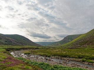 Looking down the Valley of Glen Lethnot with the Waters of Saugh gently meandering down the flat Valley Floor under the building dark clouds.