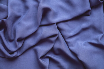Naklejka na ściany i meble Background from blue fabric in folds. The texture of the fabric.