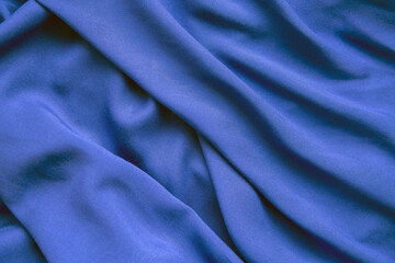 Background from blue fabric in folds. The texture of the fabric.