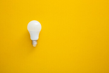 White light bulb on bright yellow background in pastel colors. Bright idea concept,