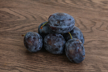 Ripe plum heap over background