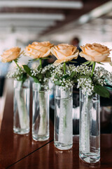 Rosen mit Schleierkraut in stylischen Gläsern zur Hochzeit vertikal