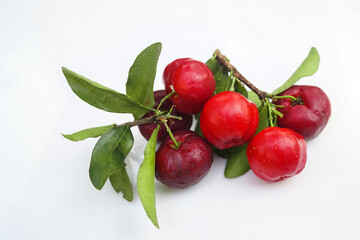 Acerola Cherry with half slice and green leaves isolated on white background