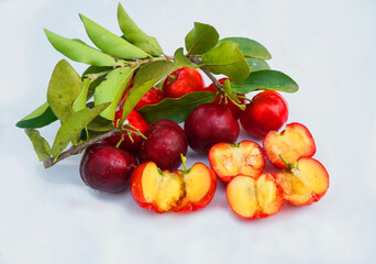 Acerola Cherry with half slice and green leaves isolated on white background
