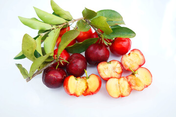 Acerola Cherry with half slice and green leaves isolated on white background