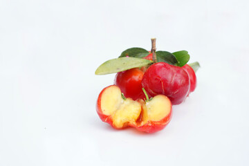 Acerola Cherry with half slice and green leaves isolated on white background