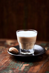 Coffee with milk on rustic wooden background. Soft focus. Close up. Copy space.