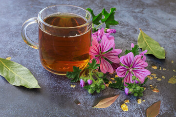 mallow herb and mallow flower tea in cup. - obrazy, fototapety, plakaty