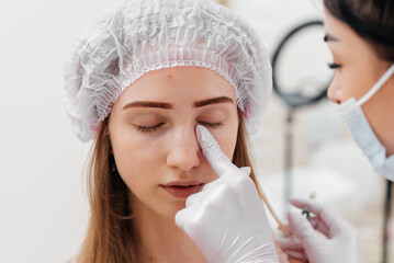 Cosmetic procedure for filling the nasolacrimal furrow and mesotherapy around the eyes for a young...