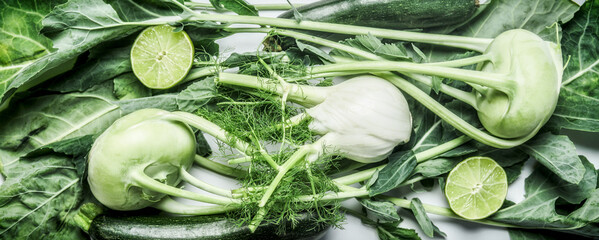 Green vegetables background with kohlrabi, fennel, zucchini and lime.  Healthy raw food. Top view.