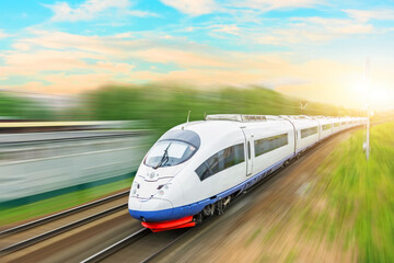 High speed fast train passenger locomotive in motion at the railway station at sunset with a...