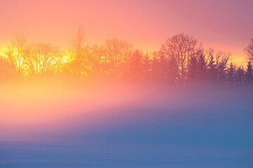 A wintry sunset with vibrant light reflecting on rising mist