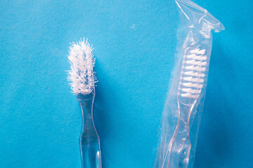 Two toothbrushes. One used and one new